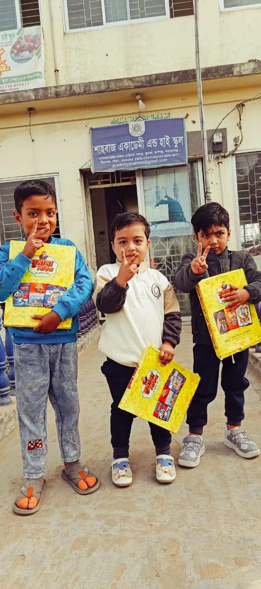 Children receiving educational materials at Shahbaz Academy